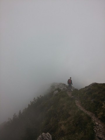 Person hiking in foggy hills alone facing the unknown